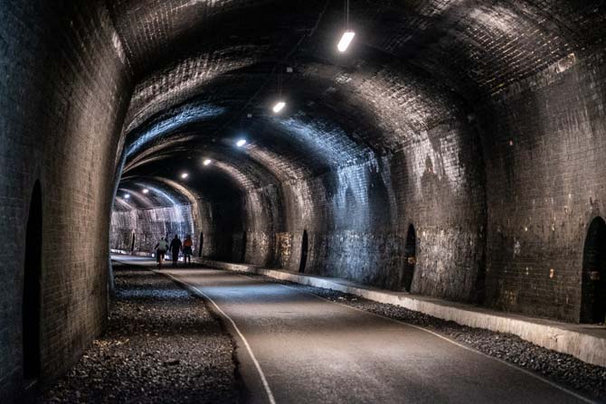 The inside of one of the tunnels along the Monsal Trail, with walkers walking through.