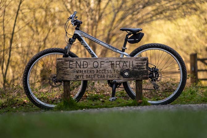 The sign at the end of the Monsal Trail at Wye Dale with a bike propped up against it.