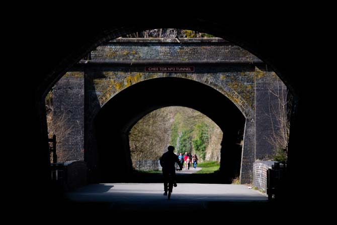The shorter Chee Tunnels, towards Wye Dale with a cyclist in silhouette.